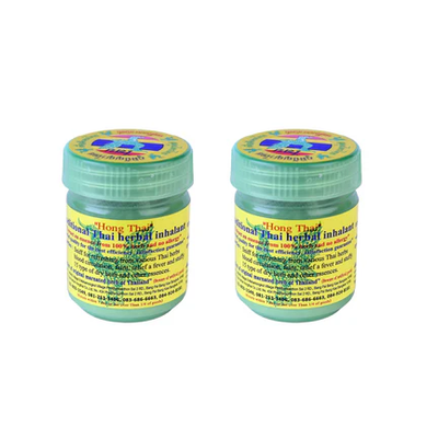 Two green jars with yellow labels on a white background